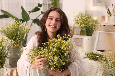 Photo of Portrait of beautiful woman with chamomile flowers indoors