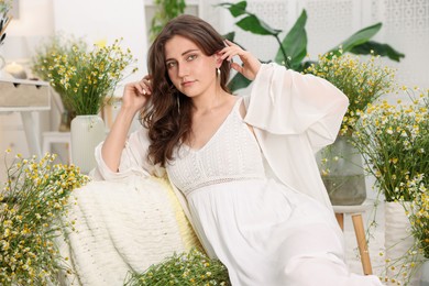 Photo of Portrait of beautiful woman with chamomile flowers indoors