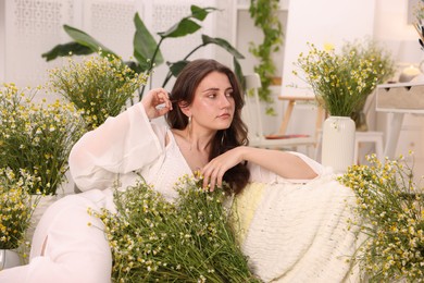 Photo of Portrait of beautiful woman with chamomile flowers indoors