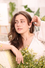 Photo of Portrait of beautiful woman with chamomile flowers indoors