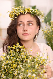 Photo of Portrait of beautiful woman with chamomile flowers indoors