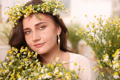 Photo of Portrait of beautiful woman with chamomile flowers indoors