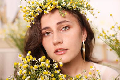 Photo of Portrait of beautiful woman with chamomile flowers indoors