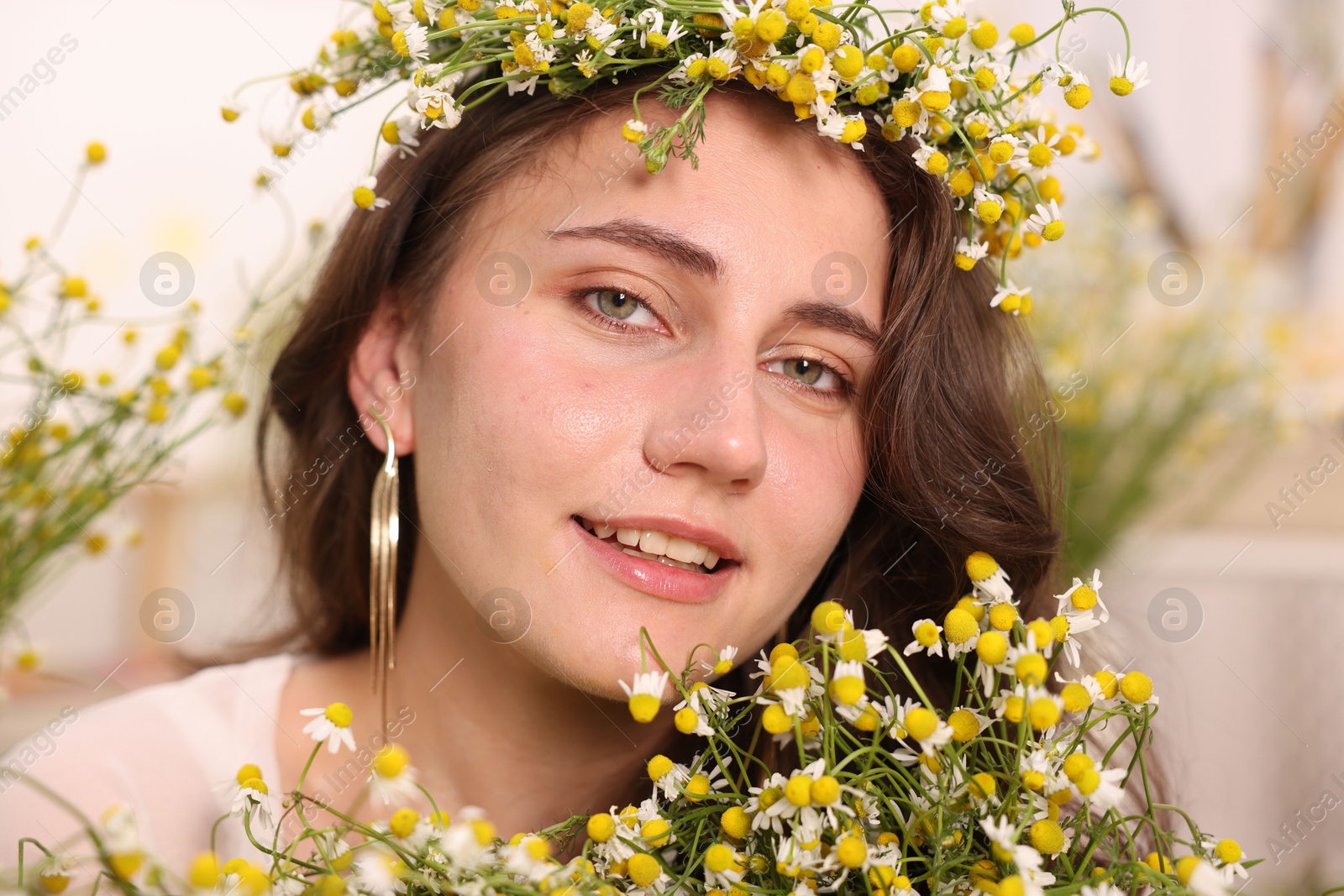 Portrait of beautiful woman with chamomile flowers indoors Photo of Portrait of beautiful woman with chamomile flowers indoors