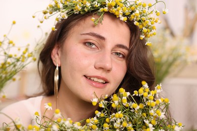 Photo of Portrait of beautiful woman with chamomile flowers indoors