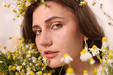 Photo of Portrait of beautiful woman with chamomile flowers indoors