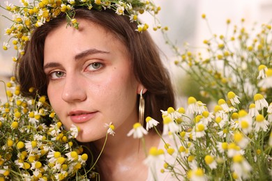 Photo of Portrait of beautiful woman with chamomile flowers indoors