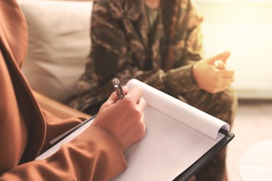 Image of Psychologist working with military officer in office, focus on hand