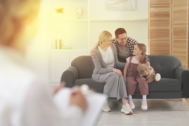 Image of Happy family having consultation with psychologist in office, selective focus
