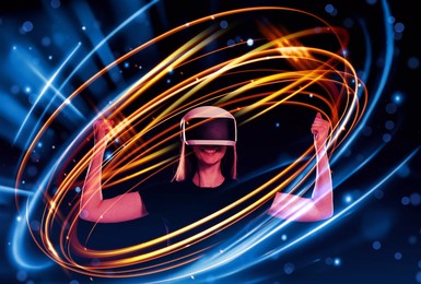 Image of Woman using virtual reality headset on dark blue background. Bright neon lines around her
