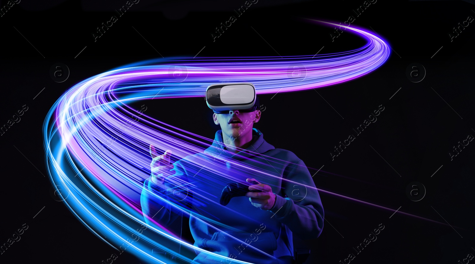 Man using virtual reality headset and controller against black background. Bright neon lines near him Image of Man using virtual reality headset and controller against black background. Bright neon lines near him
