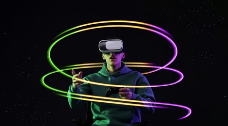 Image of Man using virtual reality headset and controller against black background. Bright neon lines around him