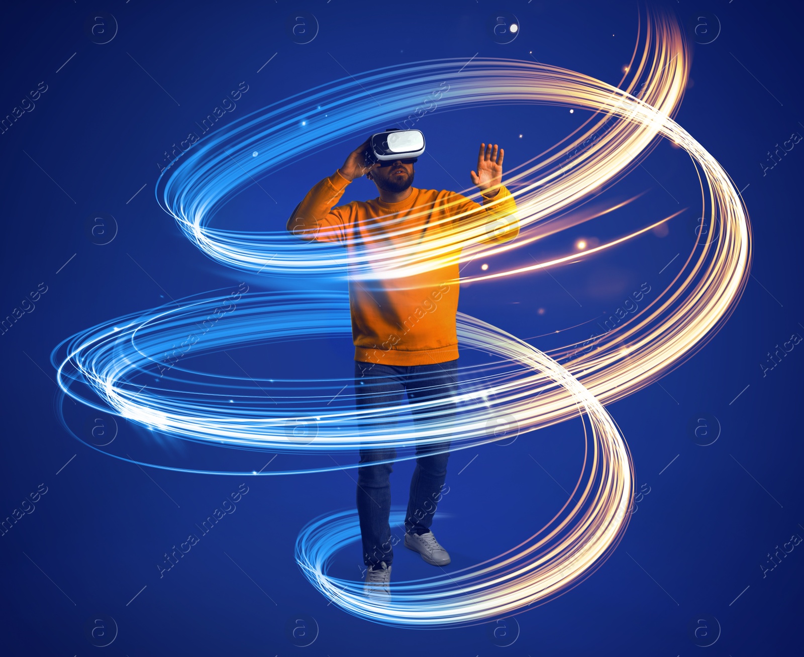 Man using virtual reality headset on blue background. Bright neon lines around him Image of Man using virtual reality headset on blue background. Bright neon lines around him