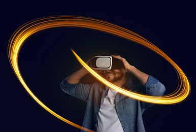 Image of Man using virtual reality headset on dark blue background. Bright neon lines around him