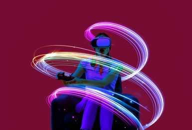 Image of Woman using virtual reality headset and controller in armchair on crimson color background. Bright neon lines around her