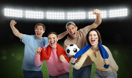 Image of Excited football fans with flags painted on their faces at stadium