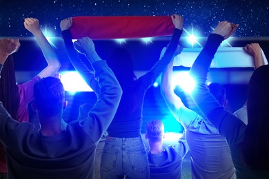 Image of Fans standing in spectator area at stadium, back view