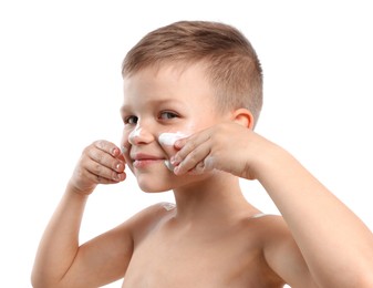 Photo of Little boy applying sun protection cream onto his skin on white background