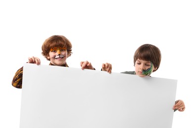 Photo of Cute boys with colorful face paintings and blank banner on white background. Space for text