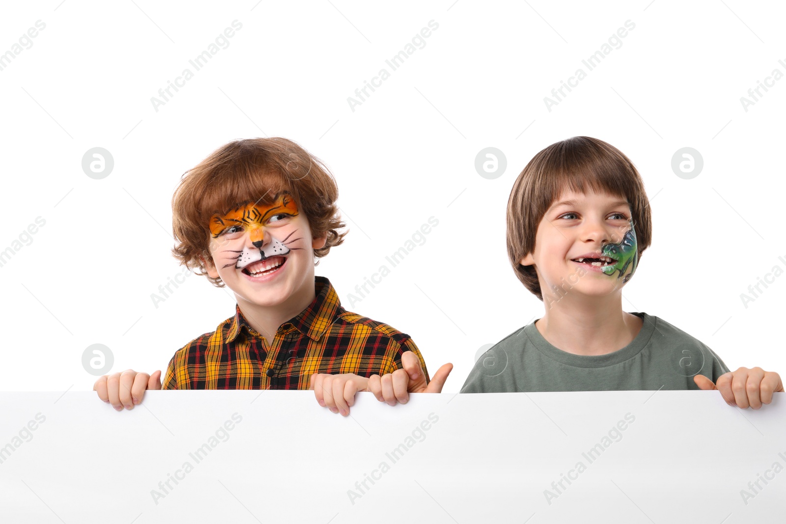 Cute boys with colorful face paintings and blank banner on white background Photo of Cute boys with colorful face paintings and blank banner on white background