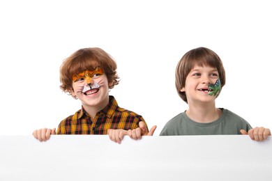 Photo of Cute boys with colorful face paintings and blank banner on white background