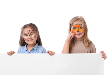 Photo of Cute girls with colorful face paintings and blank banner on white background. Space for text