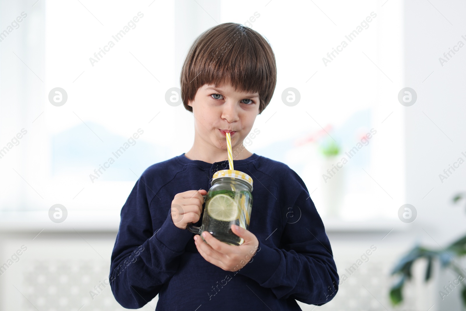 Cute little boy drinking lemonade at home. Refreshing drink Photo of Cute little boy drinking lemonade at home. Refreshing drink