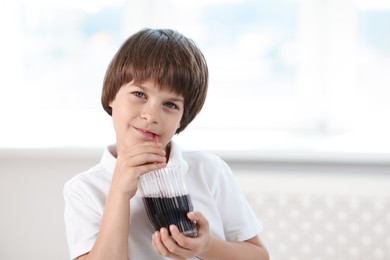Photo of Cute little boy drinking refreshing soda at home. Space for text