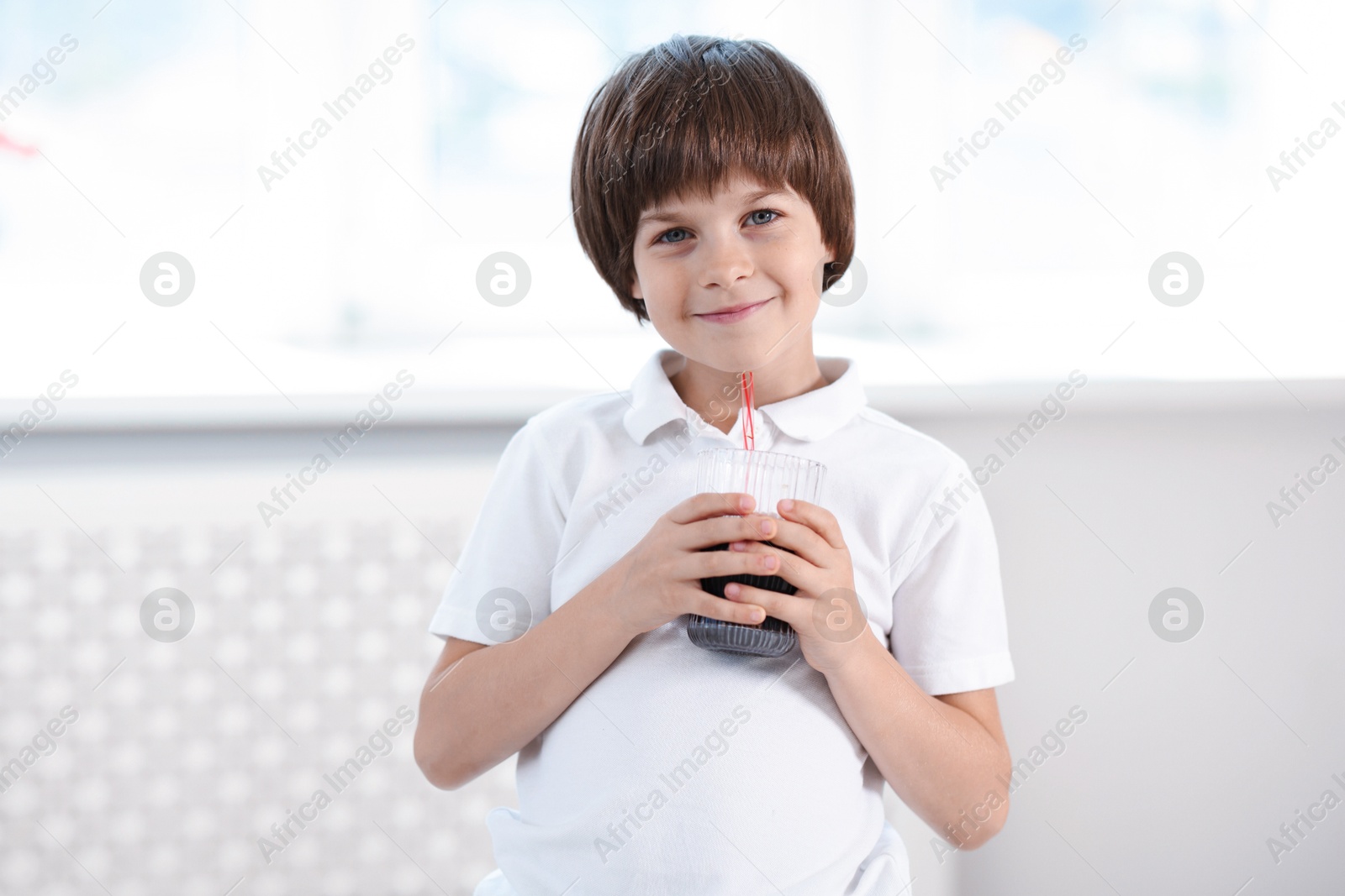 Cute little boy with glass of refreshing soda drink at home Photo of Cute little boy with glass of refreshing soda drink at home