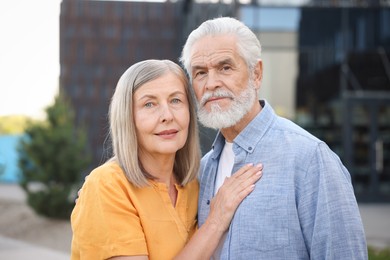 Photo of Lovely senior couple walking together on city street
