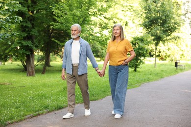 Photo of Lovely senior couple walking together in park