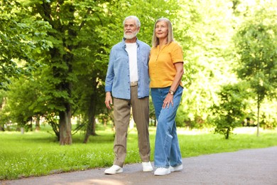 Photo of Lovely senior couple walking together in park