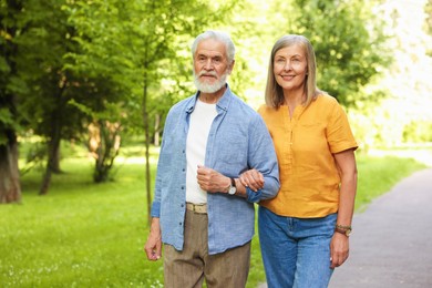 Photo of Lovely senior couple walking together in park