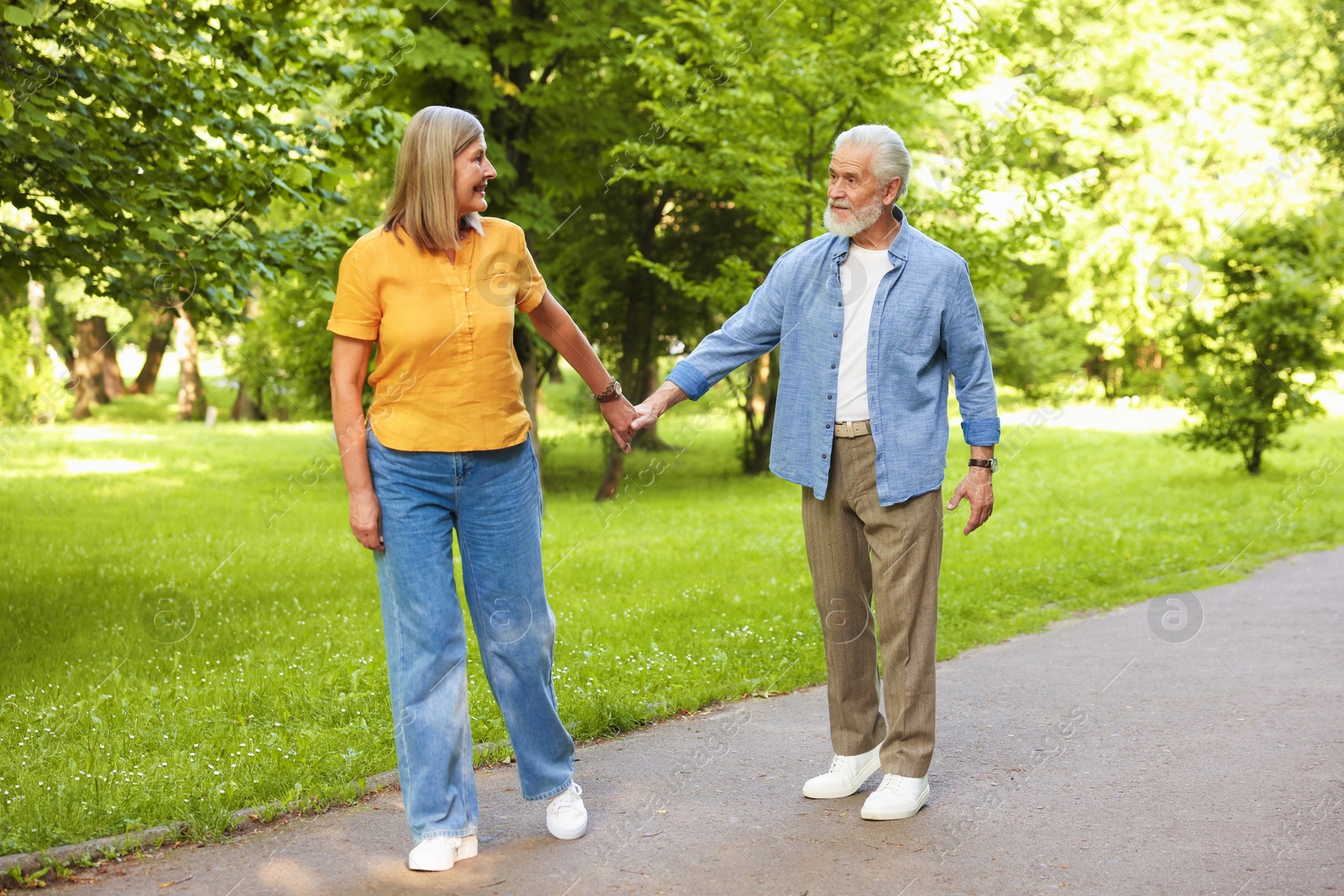 Lovely senior couple walking together in park Photo of Lovely senior couple walking together in park