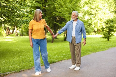 Photo of Lovely senior couple walking together in park