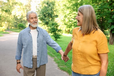 Photo of Lovely senior couple walking together in park