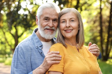 Photo of Lovely senior couple walking together in park