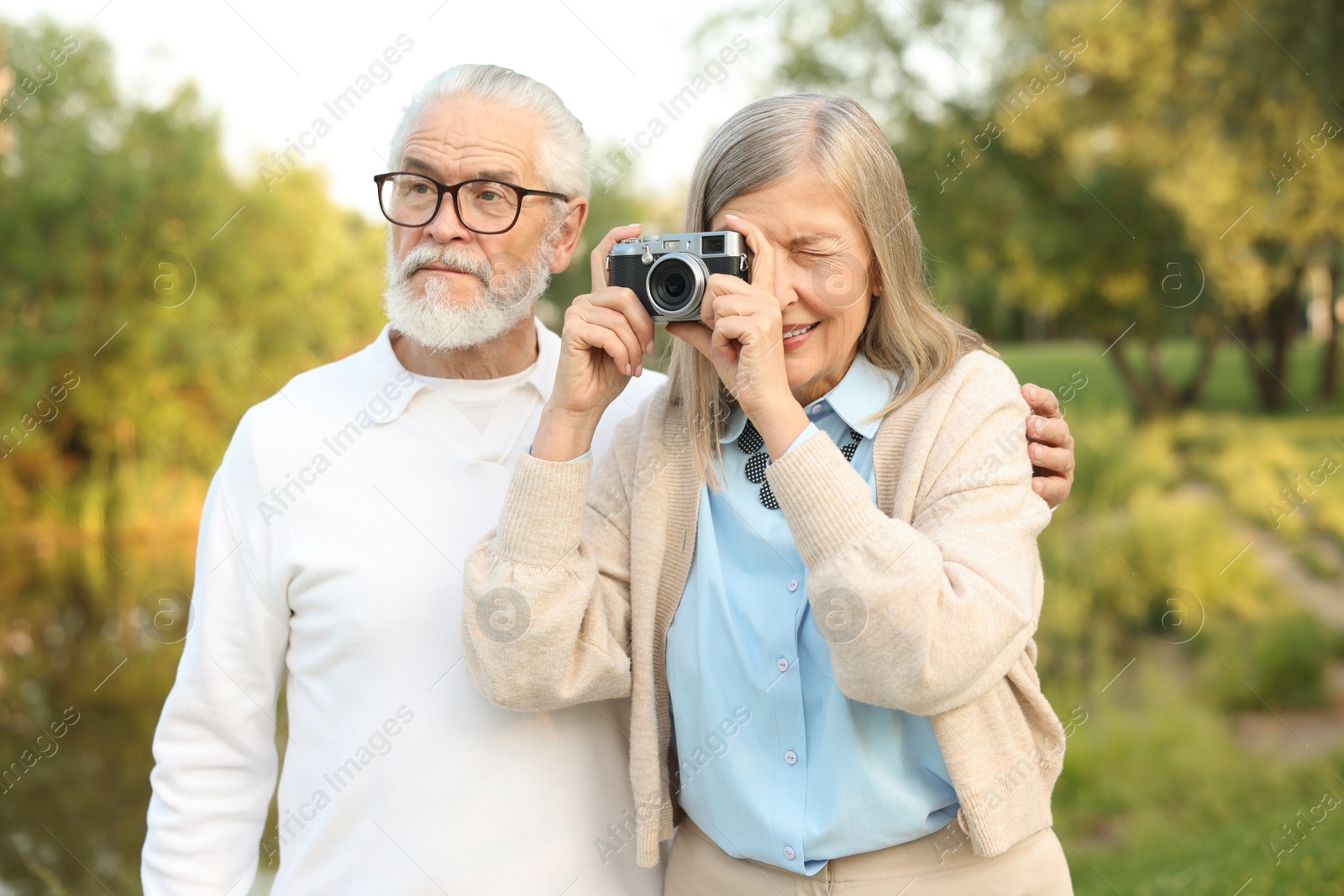 Lovely senior couple with vintage photo camera in park Photo of Lovely senior couple with vintage photo camera in park