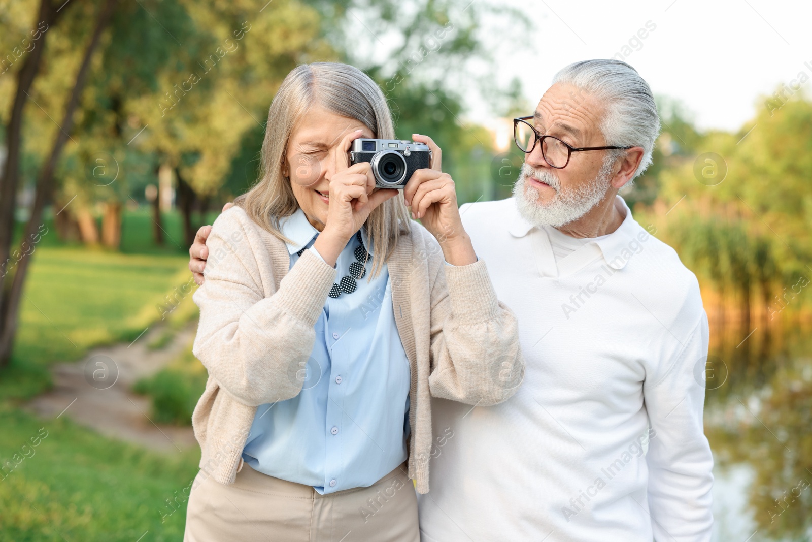Lovely senior couple with vintage photo camera in park Photo of Lovely senior couple with vintage photo camera in park