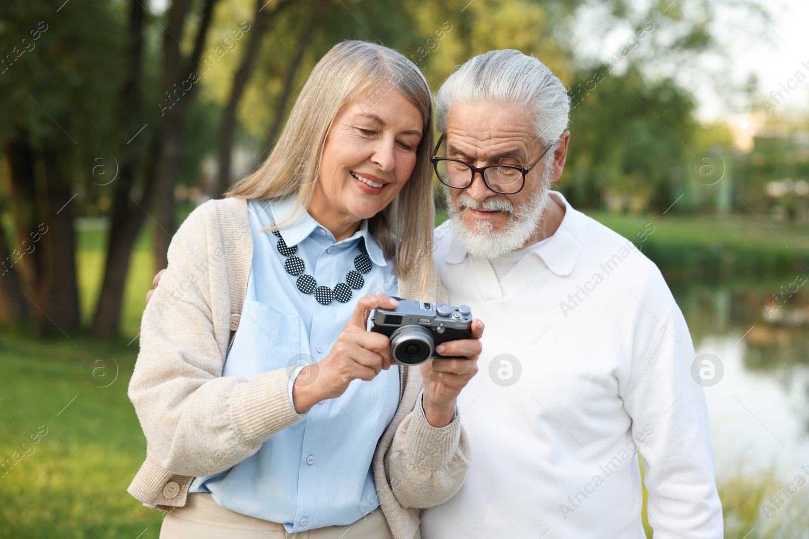 Lovely senior couple with vintage photo camera in park Photo of Lovely senior couple with vintage photo camera in park