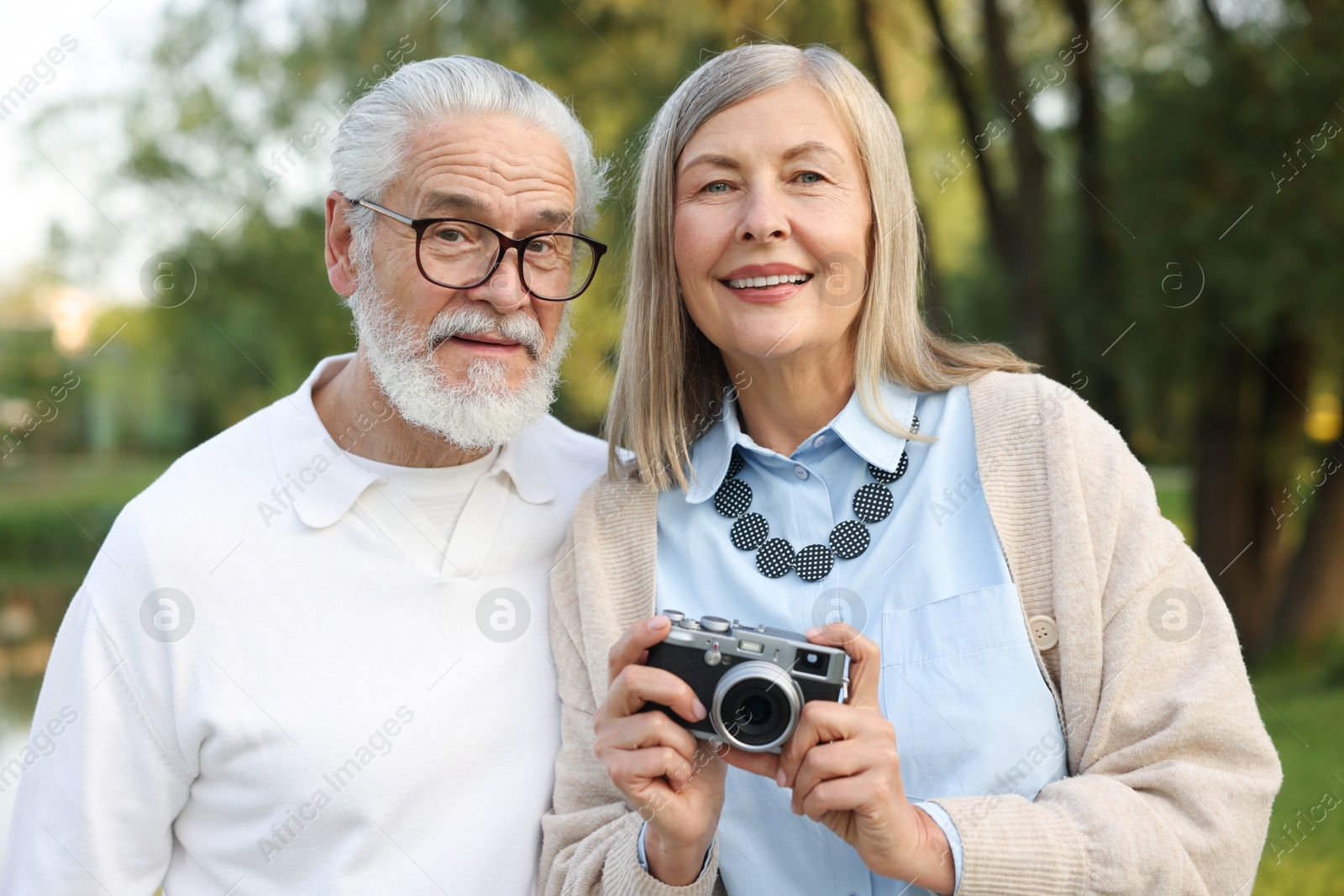 Lovely senior couple with vintage photo camera in park Photo of Lovely senior couple with vintage photo camera in park