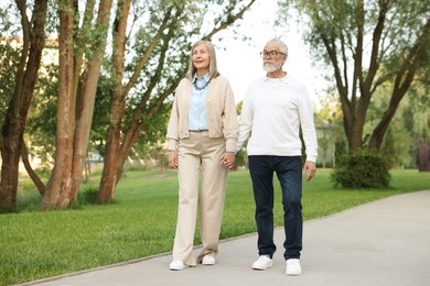 Photo of Lovely senior couple walking together in park