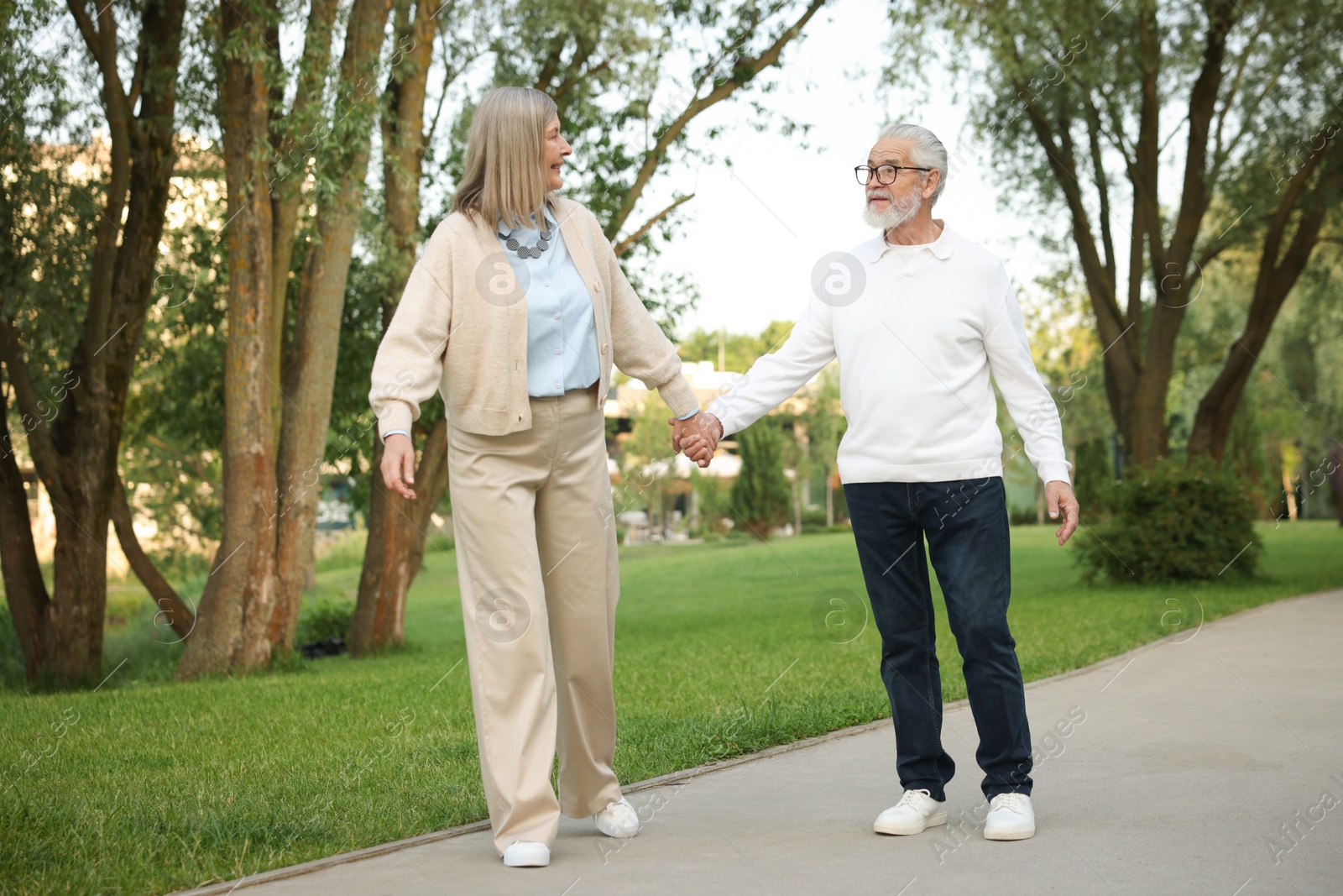 Lovely senior couple walking together in park Photo of Lovely senior couple walking together in park