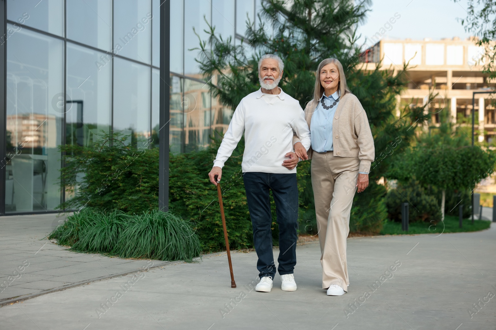 Lovely senior couple walking together near building outdoors Photo of Lovely senior couple walking together near building outdoors