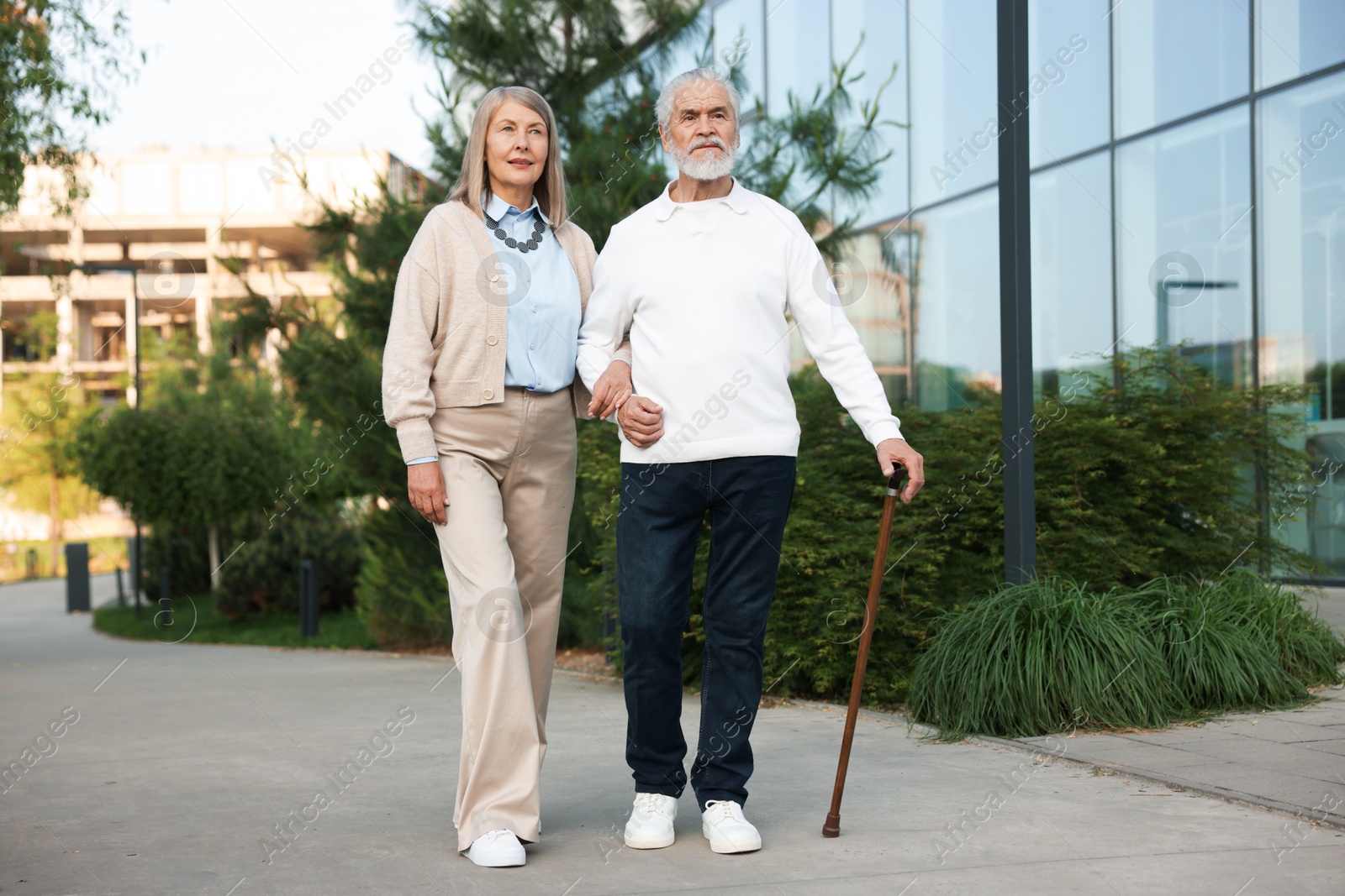 Lovely senior couple walking together near building outdoors Photo of Lovely senior couple walking together near building outdoors