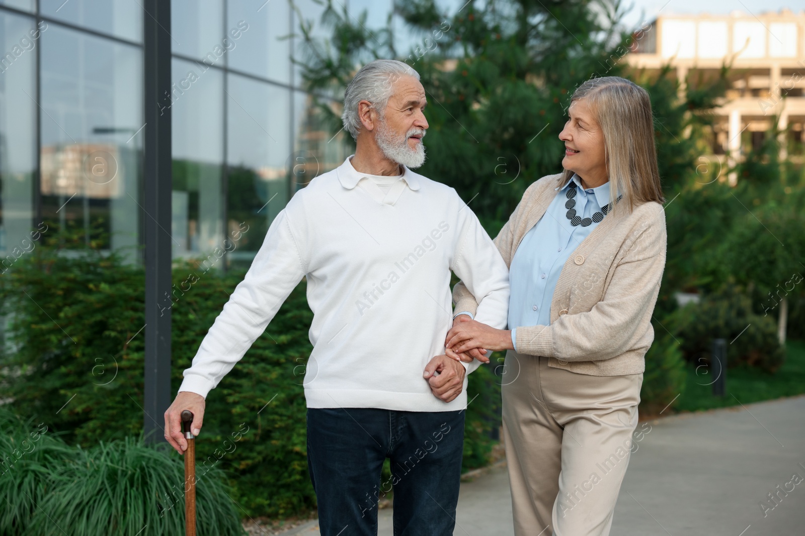 Lovely senior couple walking together near building outdoors Photo of Lovely senior couple walking together near building outdoors