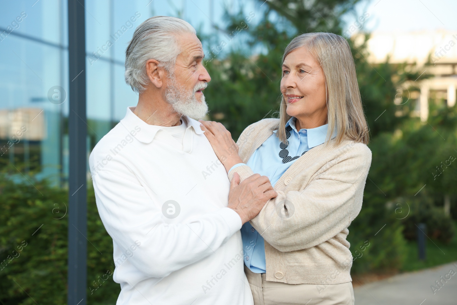 Lovely senior couple walking together near building outdoors Photo of Lovely senior couple walking together near building outdoors