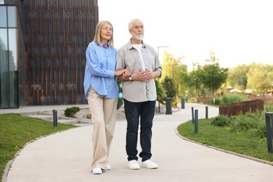 Photo of Lovely senior couple walking together in park