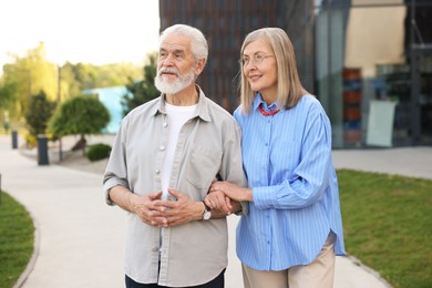 Photo of Lovely senior couple walking together in park