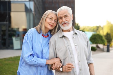 Photo of Lovely senior couple walking together in park